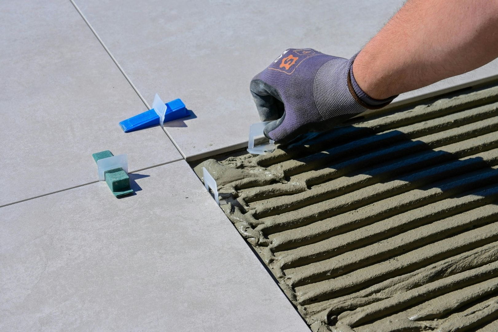 Pose soignée de carrelage grand format avec système de nivellement par un carreleur à Dreux