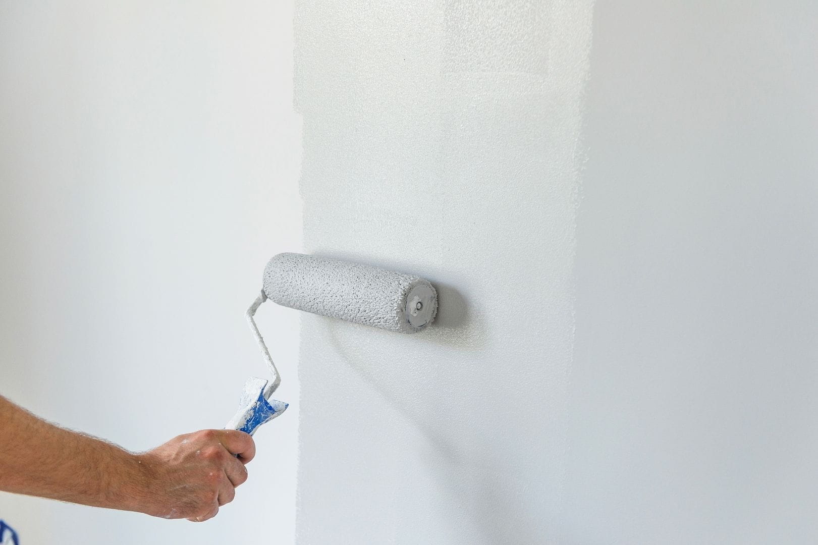 Artisan peintre appliquant une finition satinée sur les murs d'une chambre à Dreux